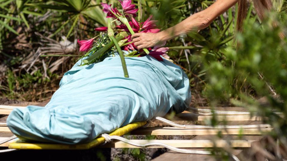 This is a burial method where body is wrapped in clothes